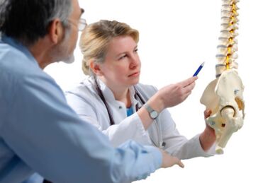 Zdravnik se posvetuje s pacientom o znakih osteohondroze torakalne hrbtenice